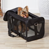 Small dog peeking out of a black pet carrier on a wooden floor.