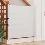 White baby gate installed on a wooden staircase